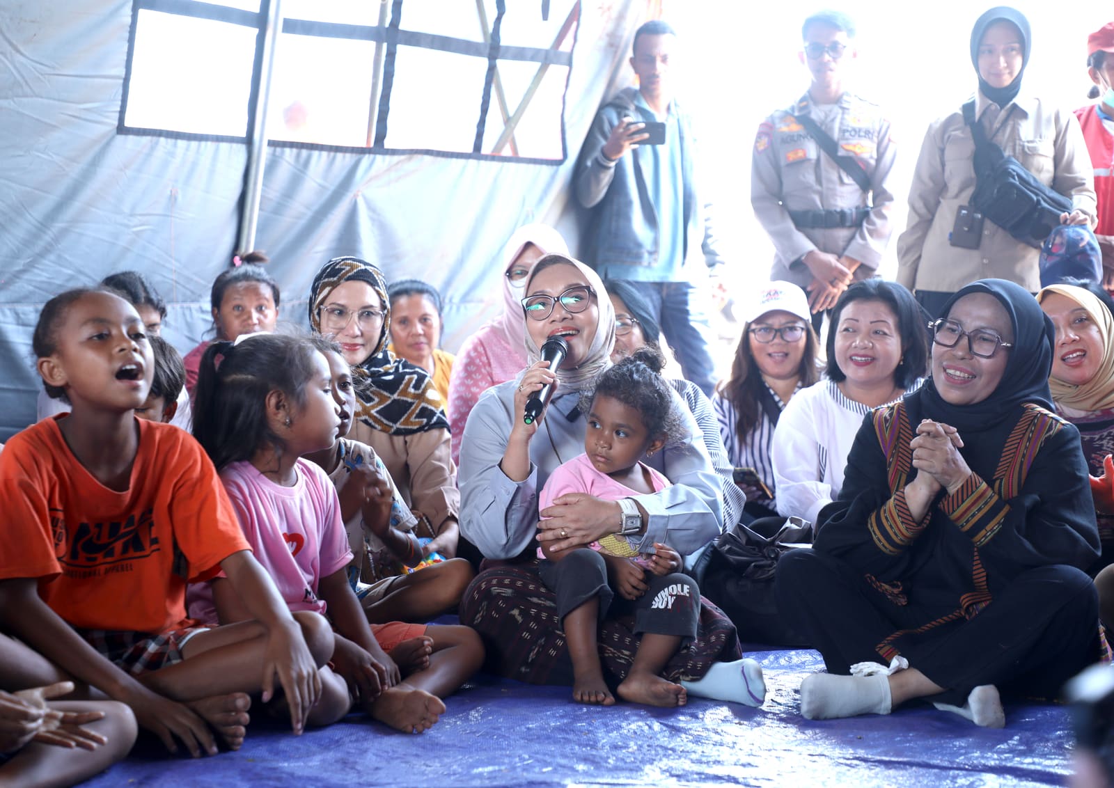 Ibu-ibu dan anak-anak berkumpul dalam kegiatan pendampingan di tenda